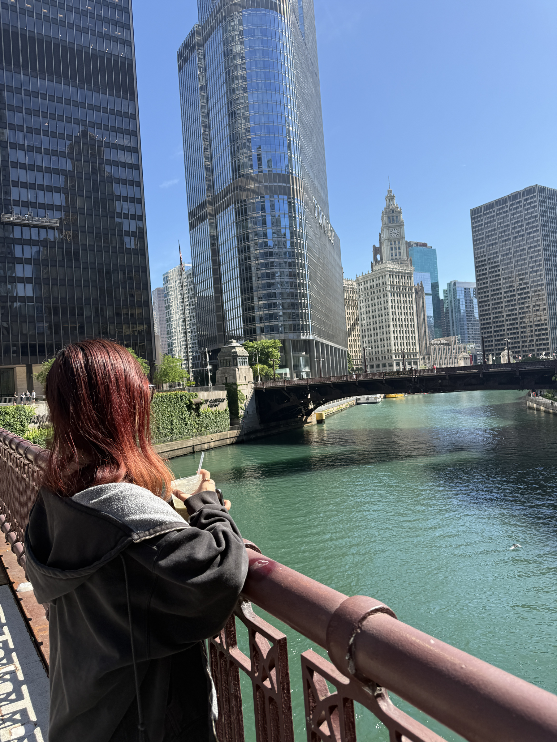 Tina Le on a bridge over the Chicago River, with the city skyline in the background