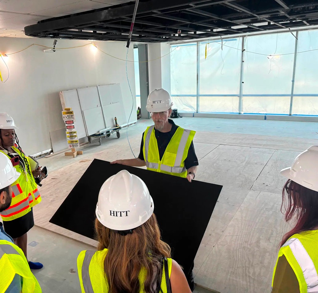 Group in hard hats reviewing plans on a construction site